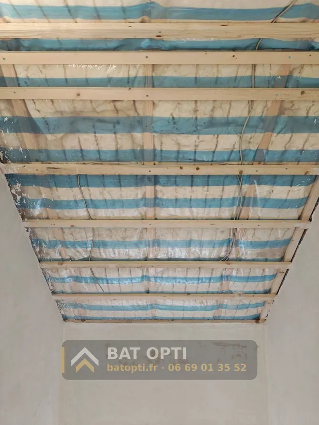 Plafond de combles isolé en laine minérale sous membrane pare-vapeur, tasseaux bois posés avant les plaques.