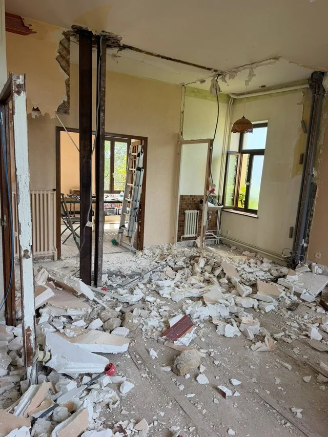 Ouverture de mur porteur : poutres IPN posées, gravats au sol, chantier en cours.