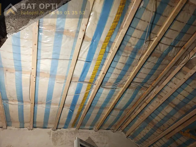 Rampants isolés en laine minérale sous membrane pare-vapeur, tasseaux bois et gaines électriques en place.
