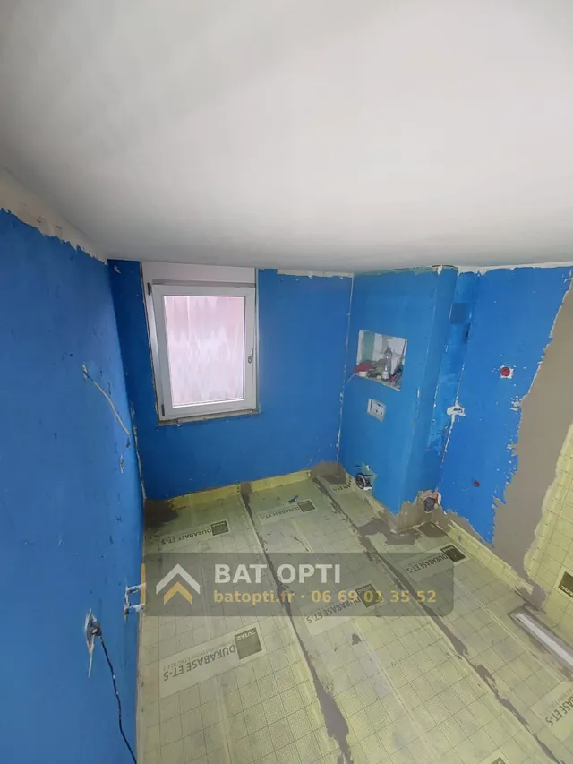 Salle de bain en cours : étanchéité appliquée sur les murs, natte d'étanchéité au sol, niche et arrivées en attente.
