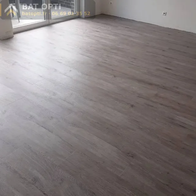 La même pièce avec son sol effet bois gris posé sur le ragréage.